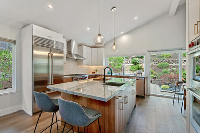 Inspiration for a mid-sized contemporary l-shaped light wood floor, brown floor and vaulted ceiling eat-in kitchen remodel in San Francisco with an undermount sink, flat-panel cabinets, white cabinets, quartzite countertops, white backsplash, an island and gray countertops