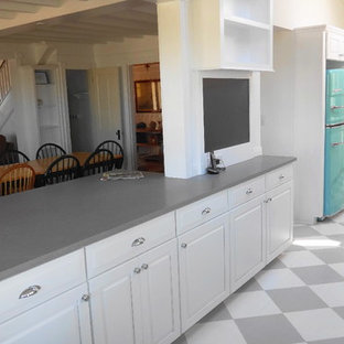 Inspiration för ett mellanstort maritimt kök, med en rustik diskho, luckor med upphöjd panel, vita skåp, bänkskiva i kvarts, vitt stänkskydd, stänkskydd i tunnelbanekakel, färgglada vitvaror, målat trägolv och en halv köksö