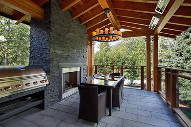 Inspiration for a large craftsman concrete paver back porch remodel in Vancouver with a fire pit and a roof extension