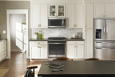 Large elegant l-shaped dark wood floor open concept kitchen photo in Orange County with an undermount sink, shaker cabinets, white cabinets, gray backsplash, stone tile backsplash and stainless steel appliances