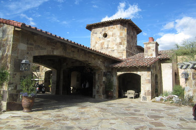 Large mediterranean beige two-story stone exterior home idea in Los Angeles