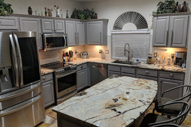 Open concept kitchen - contemporary travertine floor and multicolored floor open concept kitchen idea in Other with an undermount sink, granite countertops, beige backsplash, porcelain backsplash, stainless steel appliances and an island