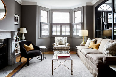 Photo of a mid-sized transitional enclosed living room in London with grey walls, light hardwood floors and brown floor.