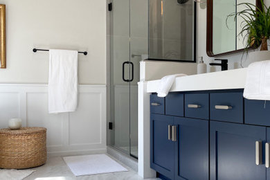 Inspiration for a mid-sized modern master gray tile and ceramic tile ceramic tile, double-sink, wainscoting and white floor bathroom remodel in Denver with blue cabinets, a one-piece toilet, an integrated sink, solid surface countertops, a hinged shower door, white countertops, a floating vanity and gray walls