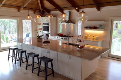 Example of a large trendy galley light wood floor and beige floor open concept kitchen design in Raleigh with an undermount sink, shaker cabinets, white cabinets, quartzite countertops, white backsplash, mosaic tile backsplash, stainless steel appliances, an island and white countertops