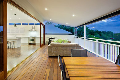 Large contemporary balcony in Brisbane with a roof extension.
