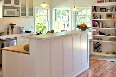 Example of a mid-sized classic u-shaped light wood floor kitchen design in San Francisco with shaker cabinets, white cabinets, marble countertops, white backsplash, subway tile backsplash, stainless steel appliances and an island