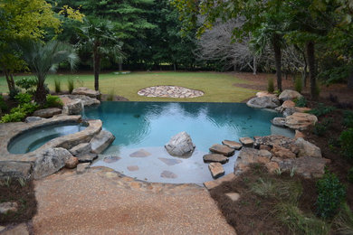 Mid-sized backyard stone and custom-shaped natural hot tub photo in Atlanta