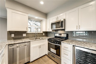 Enclosed kitchen - mid-sized transitional u-shaped medium tone wood floor and brown floor enclosed kitchen idea in Dallas with a double-bowl sink, shaker cabinets, white cabinets, granite countertops, gray backsplash, ceramic backsplash, stainless steel appliances, no island and gray countertops