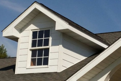 Photo of a mid-sized traditional two-storey white exterior in St Louis with vinyl siding and a gable roof.