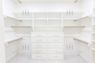 Example of a mid-sized transitional gender-neutral carpeted and white floor walk-in closet design in Dallas with flat-panel cabinets and white cabinets