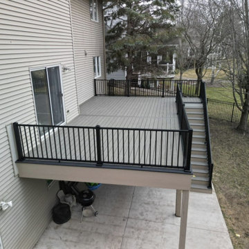 Elevated Gray Composite Deck with Stairs to Concrete Patio