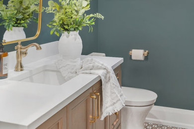 Mid-sized transitional white tile mosaic tile floor and multicolored floor powder room photo in Toronto with raised-panel cabinets, light wood cabinets, a one-piece toilet, blue walls, an undermount sink, quartz countertops and a freestanding vanity