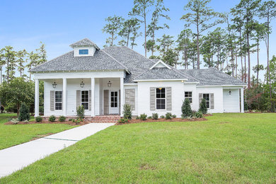 Inspiration for a mid-sized timeless white one-story wood house exterior remodel in New Orleans with a hip roof and a shingle roof