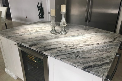Kitchen - kitchen idea in Other with white cabinets, an island and quartzite countertops