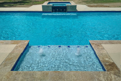 Large modern backyard rectangular lap pool in Houston with a hot tub and concrete slab.