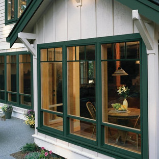 На фото: большая гостиная-столовая в стиле кантри с бежевыми стенами и темным паркетным полом без камина с