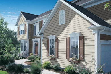 Example of a mid-sized classic beige two-story vinyl exterior home design in Other with a shingle roof