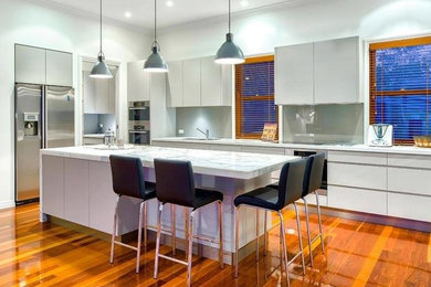 Mid-sized contemporary l-shaped open plan kitchen in Gold Coast - Tweed with louvered cabinets, white cabinets, marble benchtops and with island.
