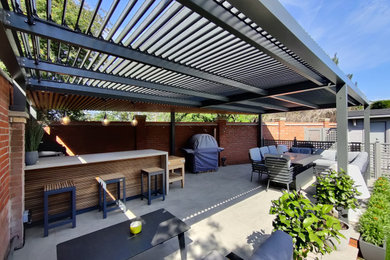 This is an example of a large modern back partial sun pergola in Essex.