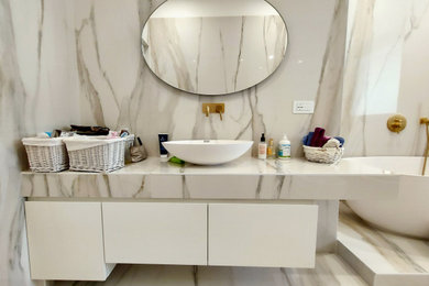 Ispirazione per una stanza da bagno padronale minimalista di medie dimensioni con ante bianche, WC a due pezzi, piastrelle in gres porcellanato, pavimento in gres porcellanato, lavabo a bacinella, un lavabo e mobile bagno sospeso