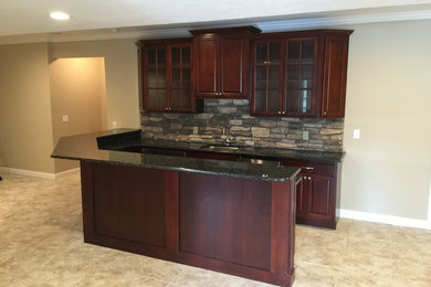 Mid-sized elegant u-shaped ceramic tile wet bar photo in Other with an undermount sink, raised-panel cabinets, dark wood cabinets, quartzite countertops, multicolored backsplash and subway tile backsplash