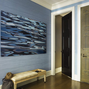 Idée de décoration pour une entrée bohème avec un mur bleu et un sol en bois foncé.