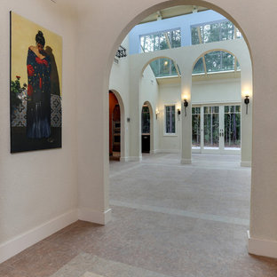 Imagen de hall mediterráneo, de tamaño medio, con paredes beige, suelo vinílico, puerta doble, puerta de madera en tonos medios y suelo beige