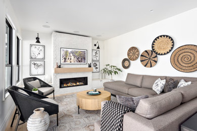 Example of a large trendy open concept light wood floor living room design in Vancouver with white walls, a standard fireplace, a brick fireplace and a wall-mounted tv