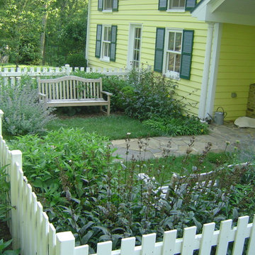 Fenced-in front yard with stone walkway and benches