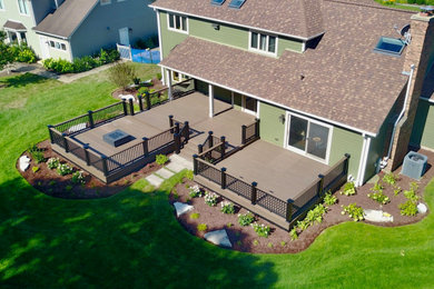 Inspiration for a large backyard ground level mixed material railing deck skirting remodel in Chicago with a roof extension
