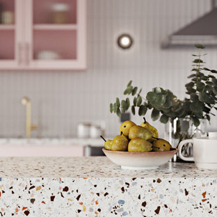 Diseño de cocina comedor lineal, minimalista, con fregadero bajoencimera, armarios tipo vitrina, encimera de terrazo, salpicadero blanco, salpicadero de azulejos de cerámica, electrodomésticos de acero inoxidable, suelo de madera clara y una isla