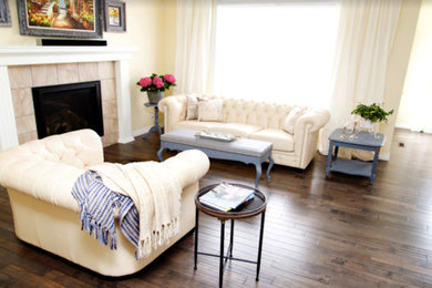 Example of a mid-sized transitional formal and open concept laminate floor and brown floor living room design in Calgary with beige walls, a standard fireplace, a tile fireplace and no tv