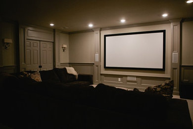 Home theater - large traditional enclosed carpeted home theater idea in Other with beige walls and a projector screen