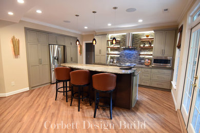 Photo of a mid-sized contemporary l-shaped open plan kitchen in Raleigh with shaker cabinets, grey cabinets, granite benchtops, multi-coloured splashback, mosaic tile splashback, stainless steel appliances, light hardwood floors and with island.