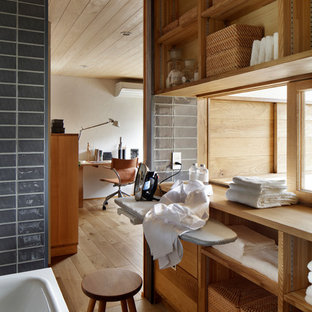 他の地域の北欧スタイルのおしゃれなランドリールーム (オープンシェルフ、中間色木目調キャビネット、グレーの壁、茶色い床) の写真