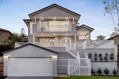 Large traditional three-storey grey house exterior in Brisbane with mixed siding, a gable roof and a metal roof.