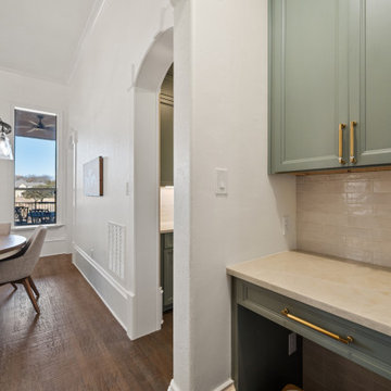 Transitional built-in desk area with sage green cabinetry and brick-stack backsp
