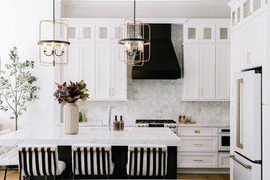 Eat-in kitchen - large transitional u-shaped medium tone wood floor and brown floor eat-in kitchen idea in Orlando with a drop-in sink, beaded inset cabinets, white cabinets, quartz countertops, gray backsplash, marble backsplash, white appliances, an island and white countertops