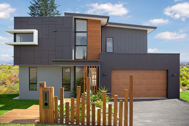 Modern two-storey blue house exterior in Central Coast with a flat roof and a metal roof.