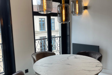 Photo of a contemporary dining room in Lille with beige walls, concrete flooring and grey floors.