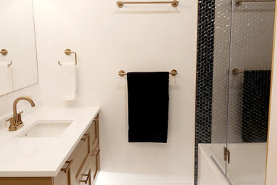 Inspiration for a small transitional kids bathroom in Ottawa with recessed-panel cabinets, medium wood cabinets, an alcove tub, a shower/bathtub combo, a one-piece toilet, blue tile, glass tile, white walls, porcelain floors, an undermount sink, engineered quartz benchtops, multi-coloured floor, a hinged shower door, white benchtops, a niche, a single vanity and a floating vanity.