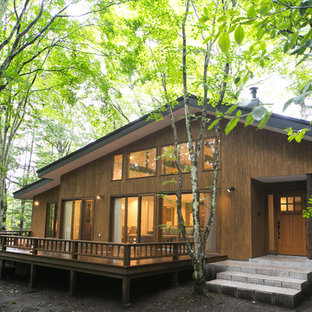 他の地域のアジアンスタイルのおしゃれな家の外観 (木材サイディング、茶色い外壁) の写真