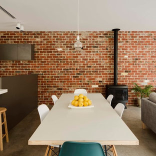 Design ideas for an industrial open plan dining in Melbourne with concrete floors, a wood stove, a metal fireplace surround and grey floor.