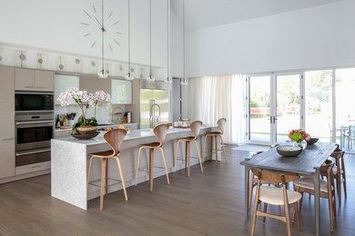 Example of a large trendy u-shaped dark wood floor open concept kitchen design in New York with an undermount sink, flat-panel cabinets, marble countertops, stainless steel appliances and an island