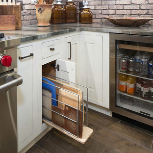 Mid-sized industrial kitchen pantry in Atlanta with a farmhouse sink, beaded inset cabinets, quartzite benchtops, brick splashback, stainless steel appliances and with island.