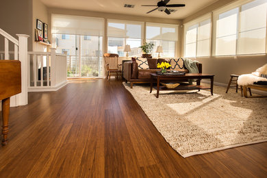 Example of a mid-sized open concept bamboo floor living room design in San Francisco with white walls and no fireplace