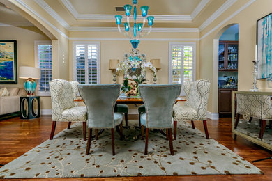 Example of a mid-sized transitional medium tone wood floor and brown floor great room design in Orange County with beige walls and no fireplace