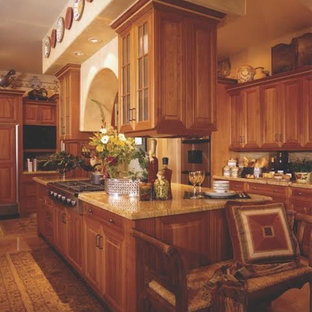 Mid-sized traditional kitchen pantry ideas - Mid-sized elegant l-shaped ceramic floor kitchen pantry photo in Cedar Rapids with raised-panel cabinets, medium tone wood cabinets, granite countertops, beige backsplash, stainless steel appliances and an island