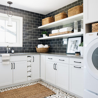 Photo of a rural l-shaped utility room in Chicago with a submerged sink, shaker cabinets, white cabinets, black walls, a side by side washer and dryer, white floors and grey worktops.